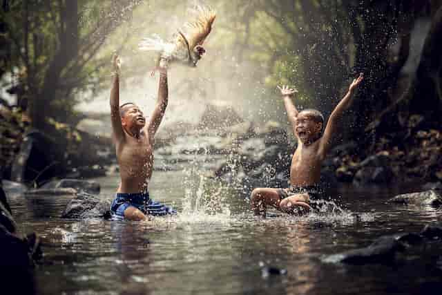 Children Playing in Water of a Stream Living in Joy