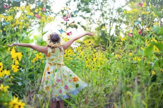 LIttle Girl Rejoicing in Flowers finding Contentment, Fulfillment and joy.