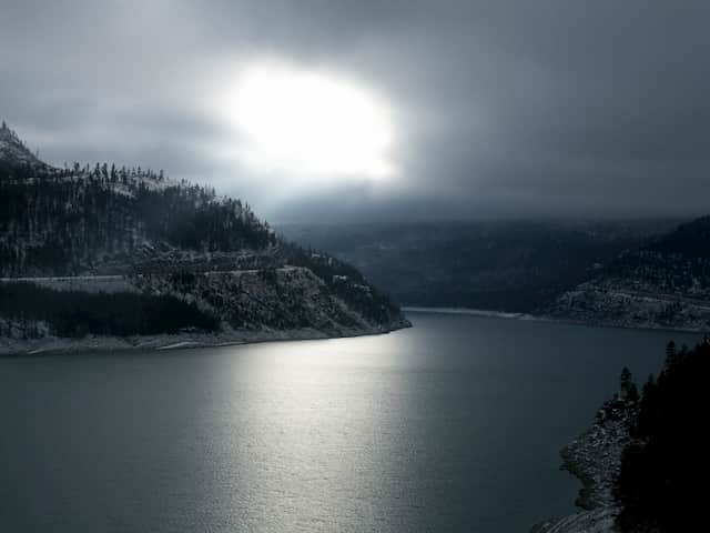 Sun Shining Through Clouds on the Water and Mountains