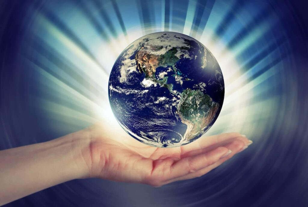 Image of Earth glowing with an arm and hand cupping it from below.